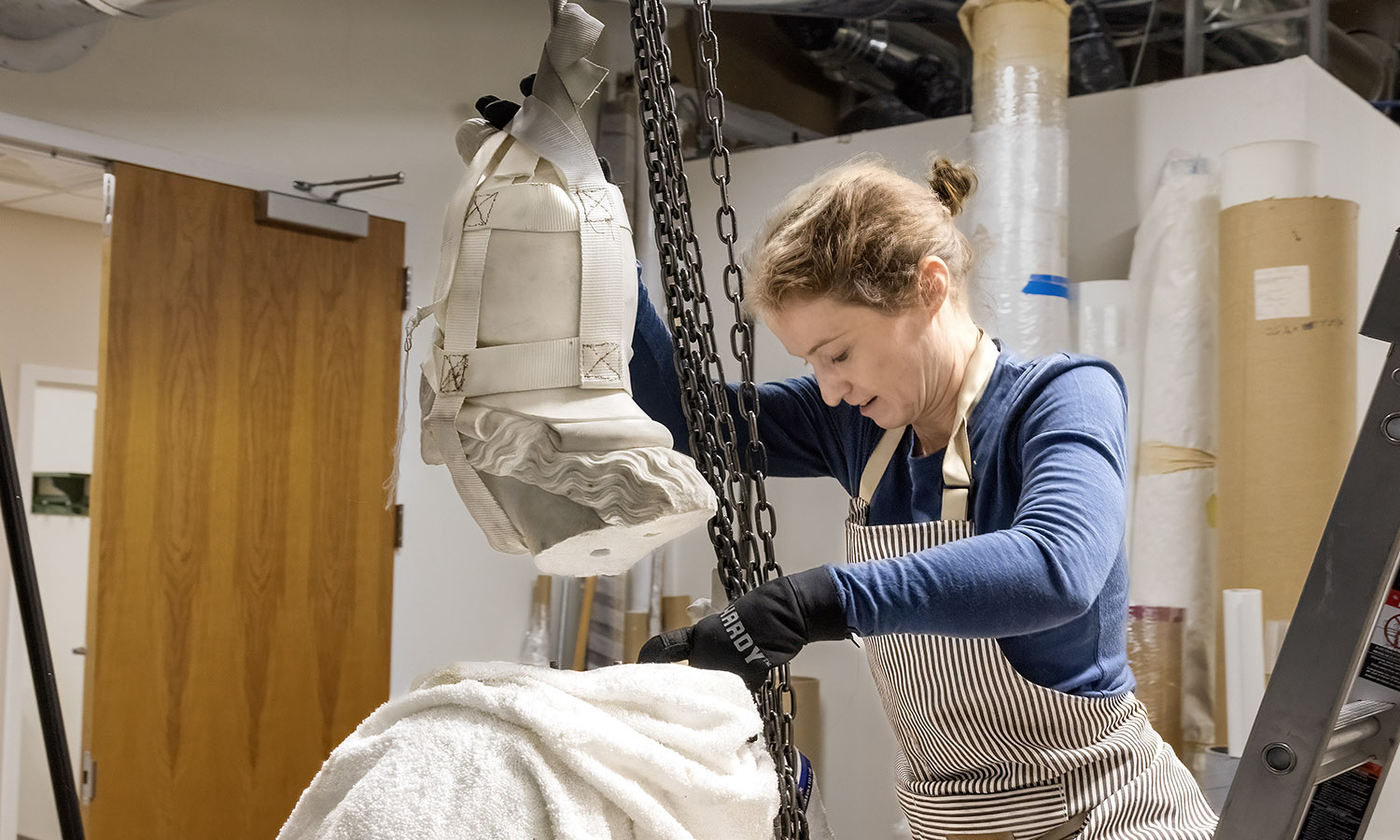 Conservator Lauren Paige Isaacs carefully aligns Minerva's head.