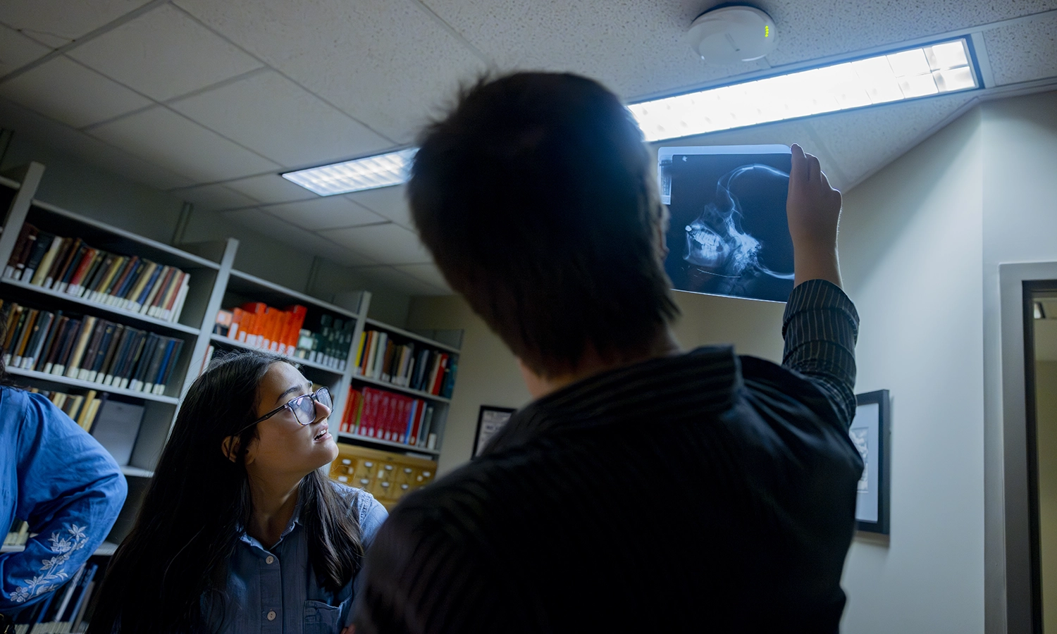 two people hold up an x-ray of a skull