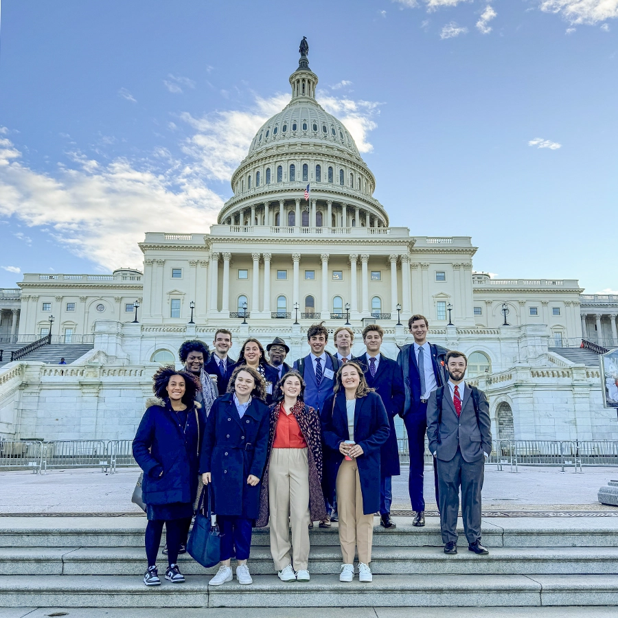During the Day on the Hill program, students gather with Associate Professor of Politics DeWayne Lucas in front of the U.S. Capitol building in Washington, D.C.
