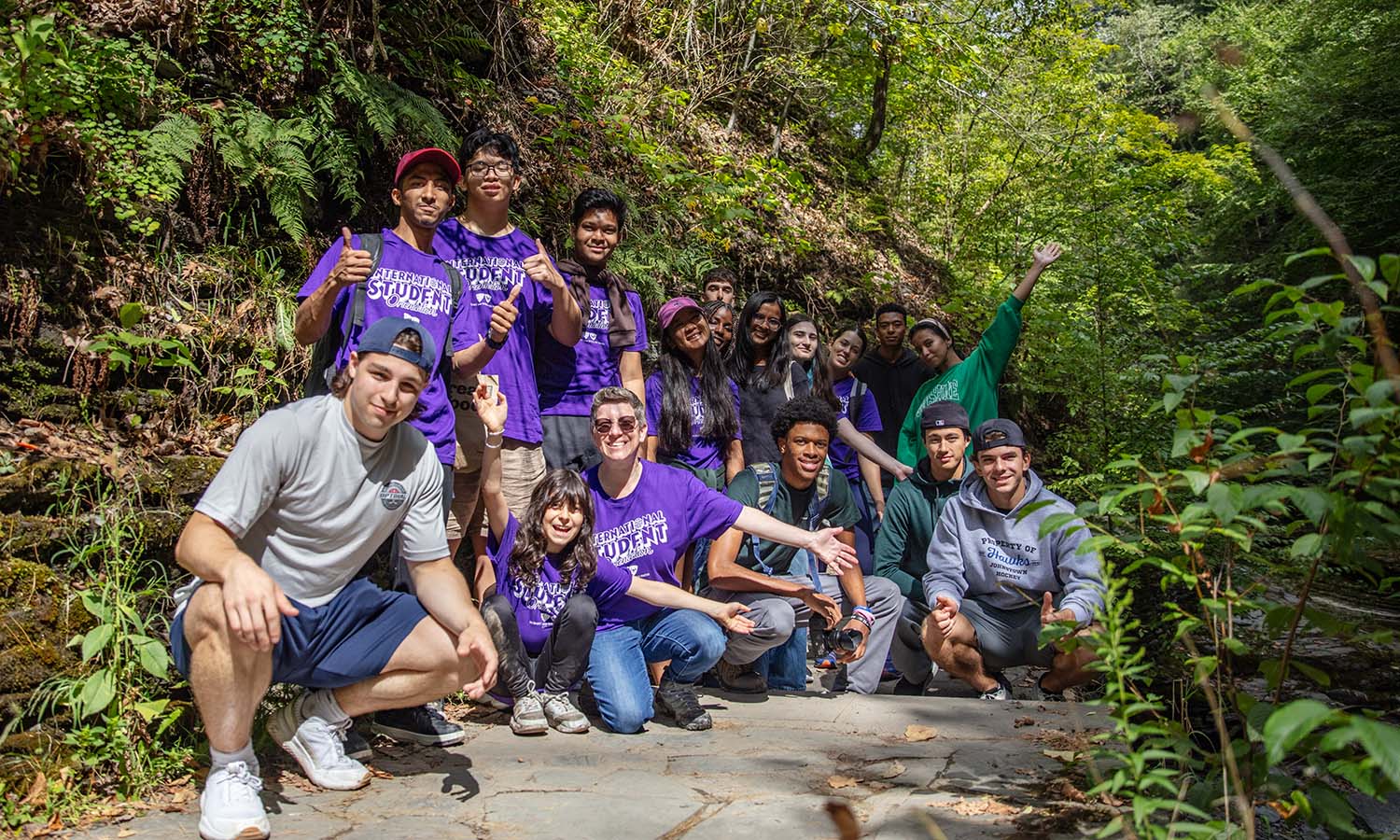 International Student Success Manager Sherri Martin-Baron joins students for a group photo during the International Student Orientation trip to Watkins Glen State Park. 