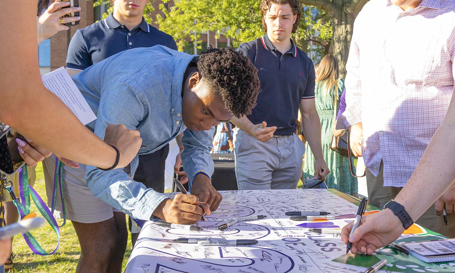 Members of the Class of 2029 sign their class banner following the Convocation ceremony. 