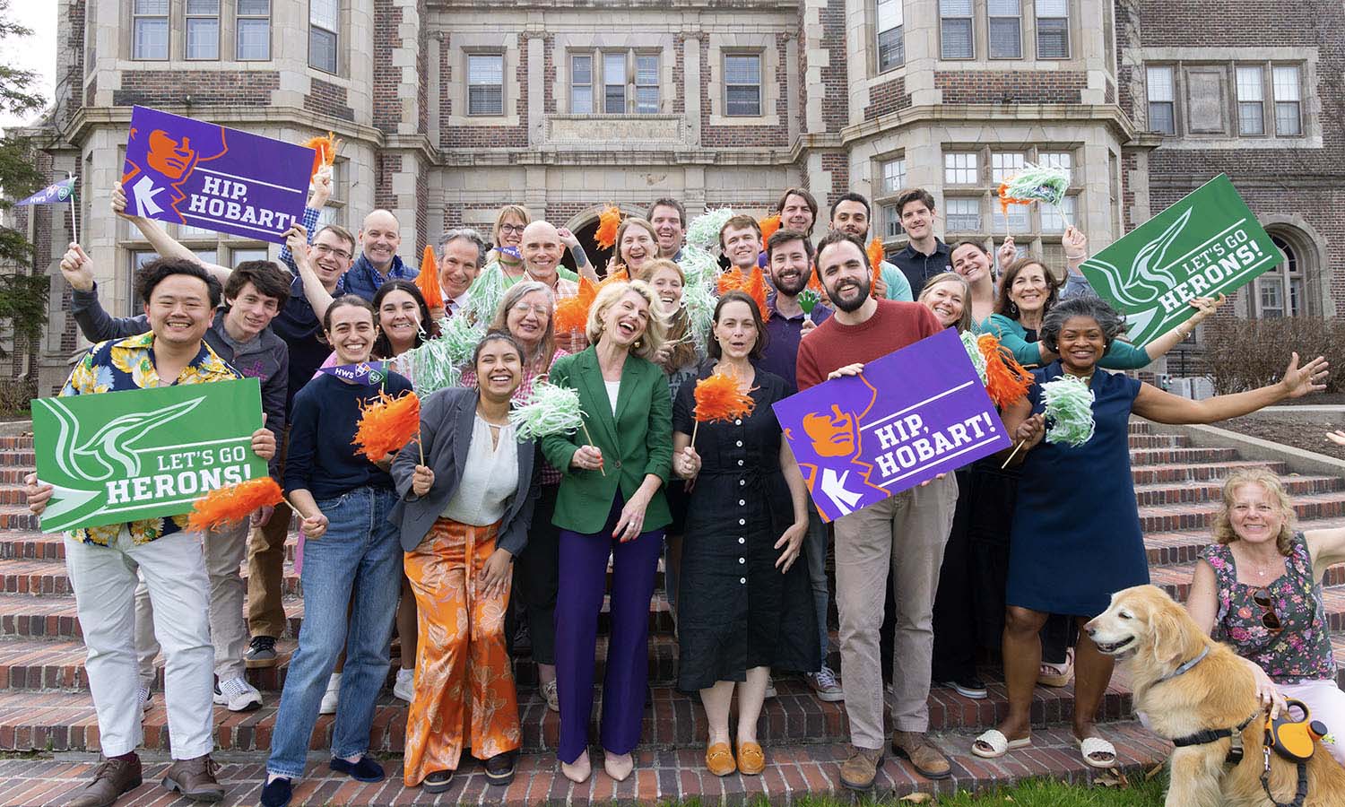 Faculty and staff who are also HWS alumni pose for a photo on the steps of Coxe Hall with Melanie Sage ’95, P’25, P’27 (center), the Executive Director of Alumni and Alumnae Relations. 