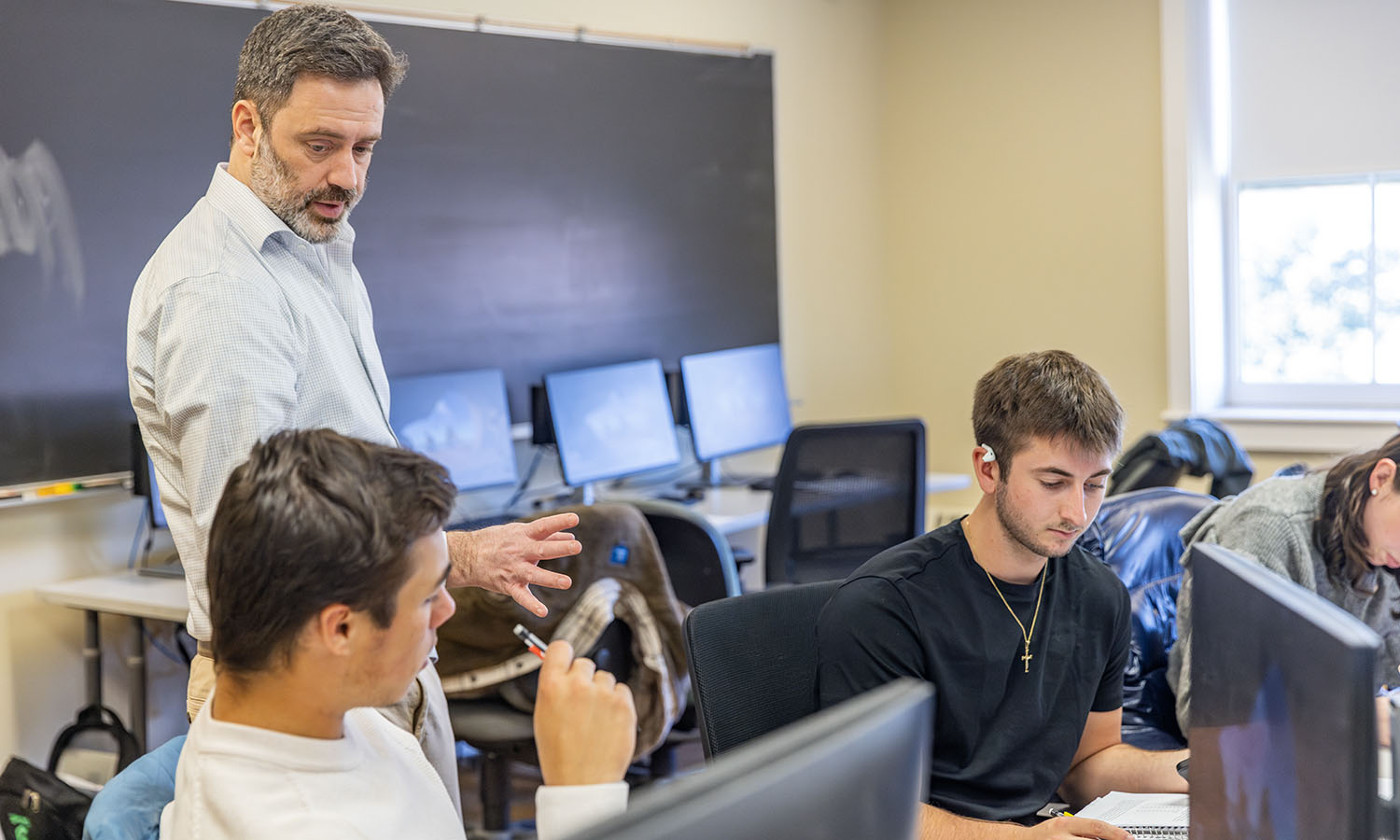 Associate Professor of Economics Joshua Greenstein assists students with a problem set in "Statistics." 
