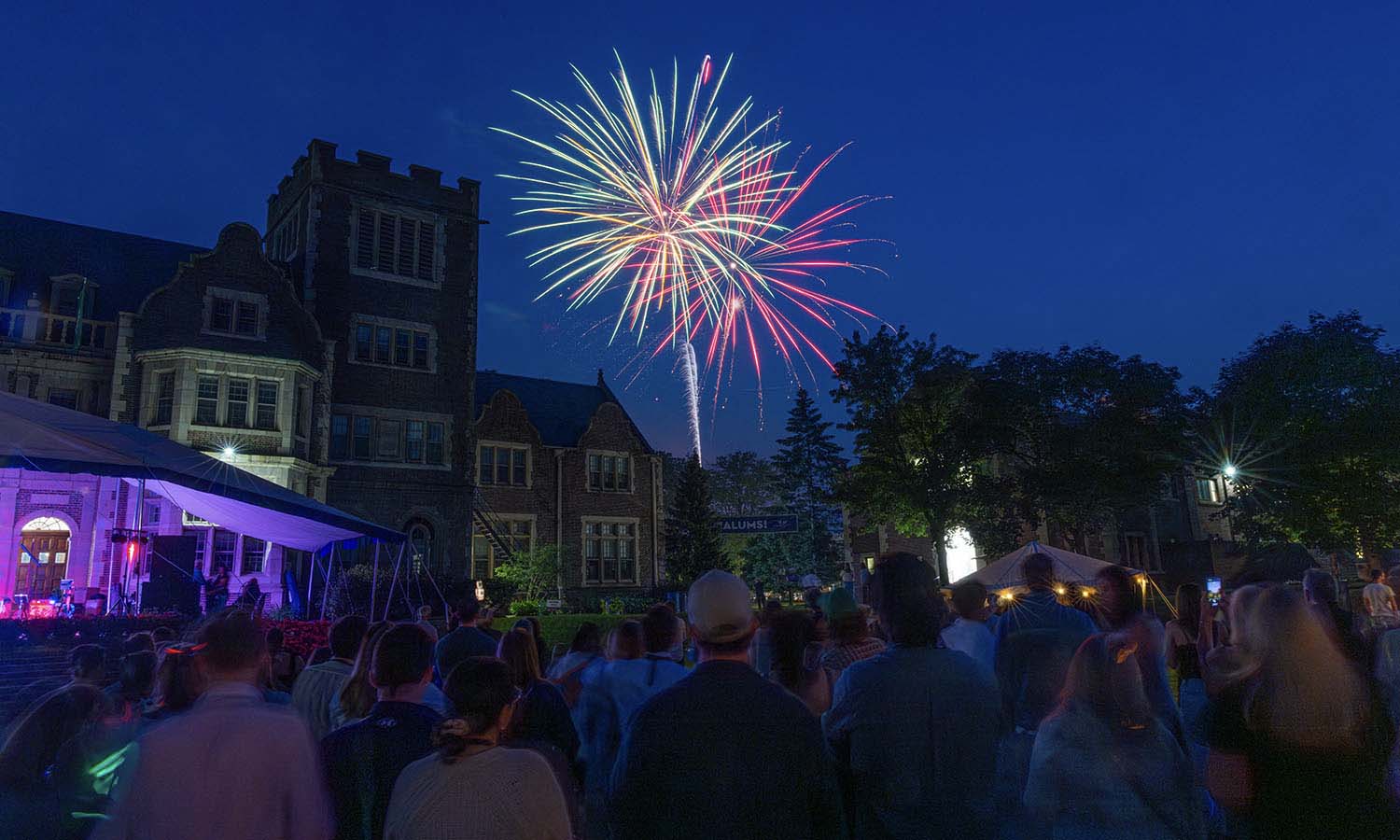 Alumni look on as fireworks illuminate the sky during Reunion Weekend. 