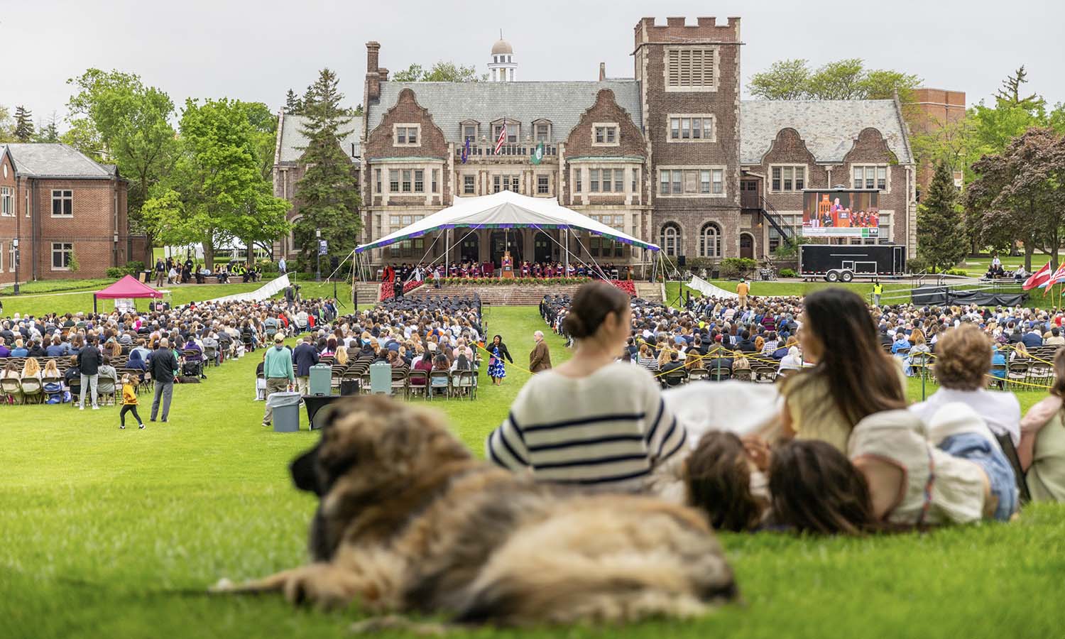 Family and friends watch the Commencement ceremony from the hill on the Quad. 
