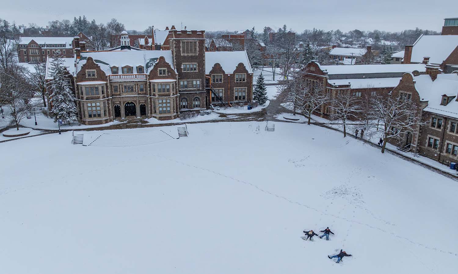 Students make snow angels on the Quad. 