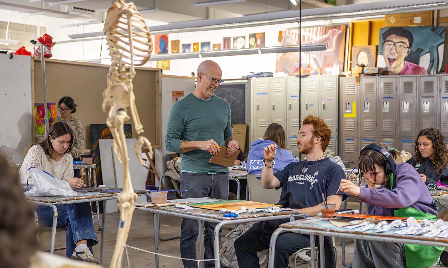 Professor of Art and Architecture Nick Ruth provides feedback to students as they complete observational paintings of a skeleton during “Representationl Painting.” 