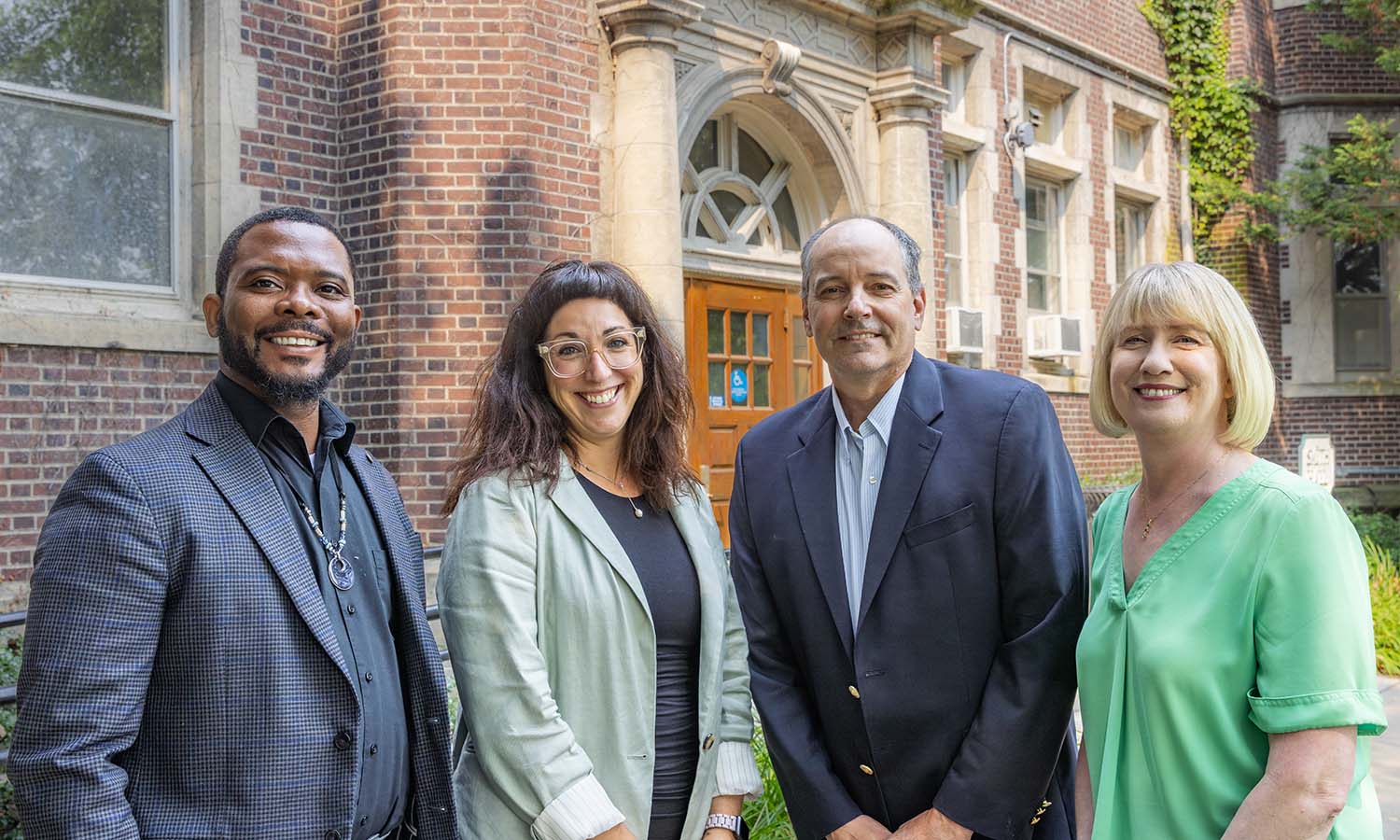 The four Hobart and William Smith Deans, Kelvin Clark, Kelly Payne, David Mapstone ’93, P’21 and Amy Green pose for a photo outside of Smith Hall. 