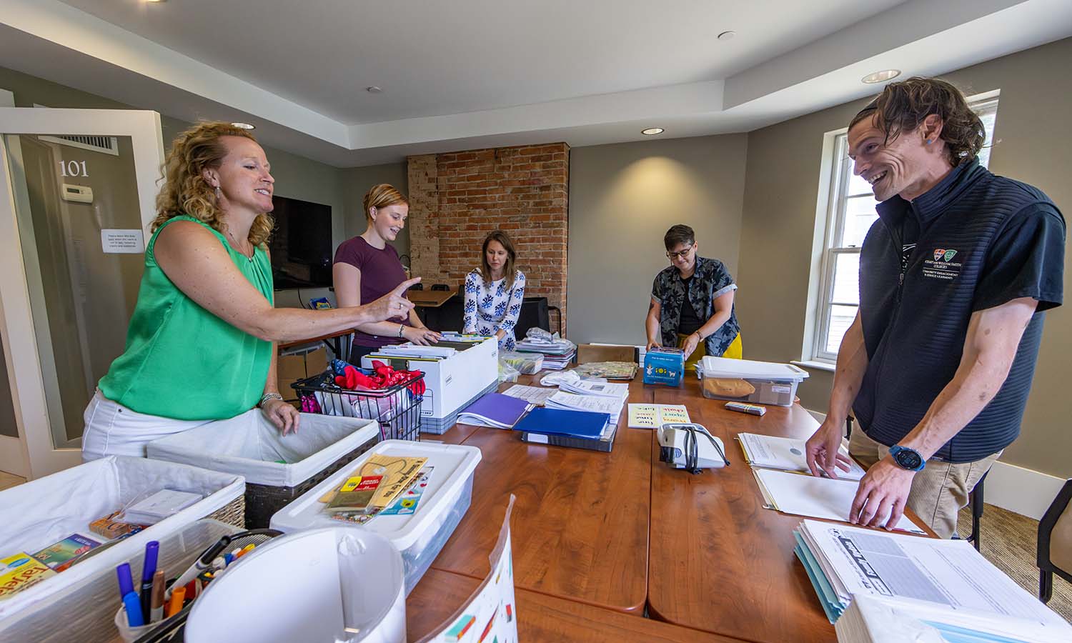 Now at home at 603 S. Main St., the staff from the Center for Community Engagement and Service Learning and the Centennial Center for Leadership pack binders for America Reads. 