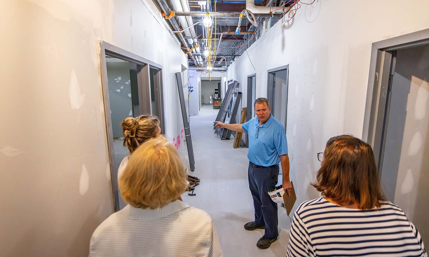 Senior Project Manager Chris Button leads staff from the Office of Communications on a tour through Gulick Hall, which is being renovated to house the Departments of Psychology, Mathematics, Computer Science and Physics. 