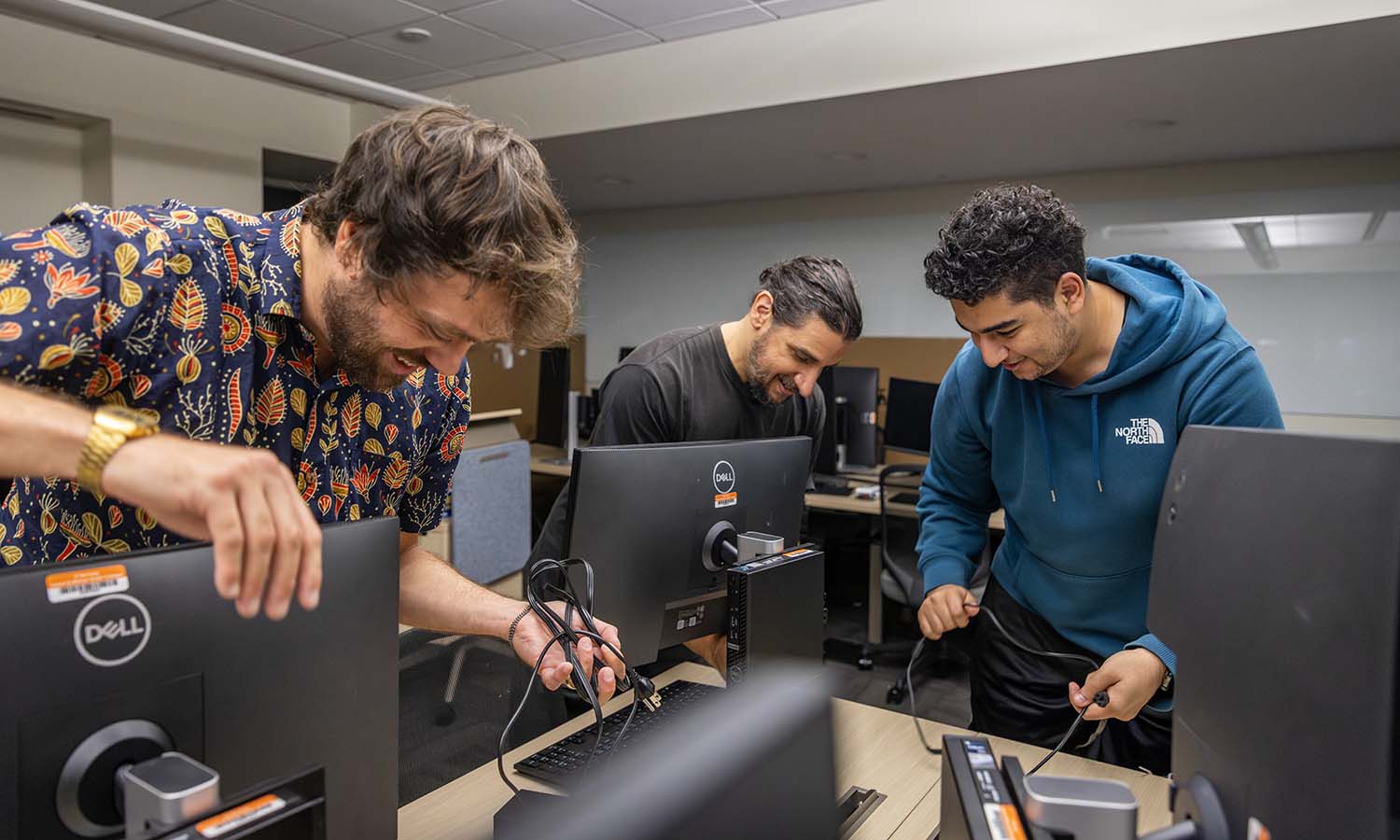Instructional Technologist for Digital Media Casey Puccini, Technical Support Manager Joe Calabrese and Student Technician Sayf Elhawary ’25 set up a new computer lab in Demarest Hall. 