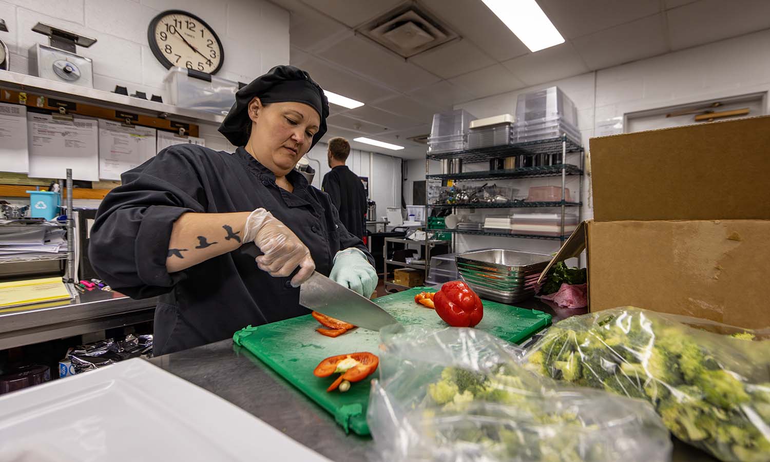 Saga Cook Andrea Poorman chops vegetables for salads in the kitchen on Thursday. 