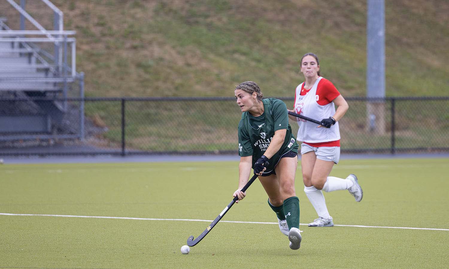 Abby Jones ’25 dribbles down the field as the William Smith field hockey team takes on Cortland in a preseason scrimmage on Wednesday. 