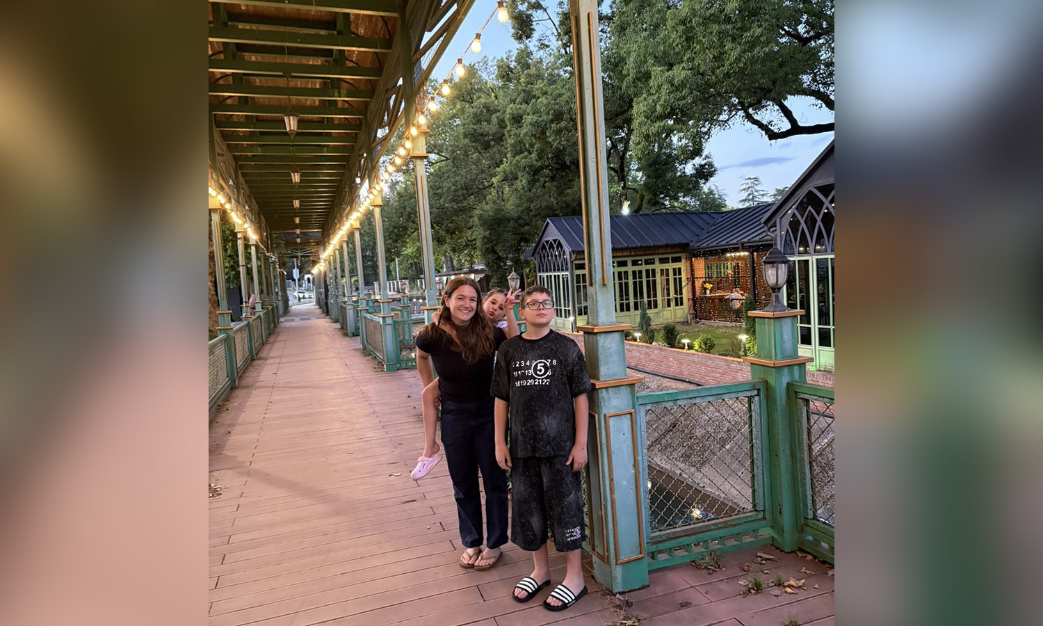 Kelly Howe ‘26 poses for a photo with her host siblings Cecily and Saba after dinner in Kutaisi. 