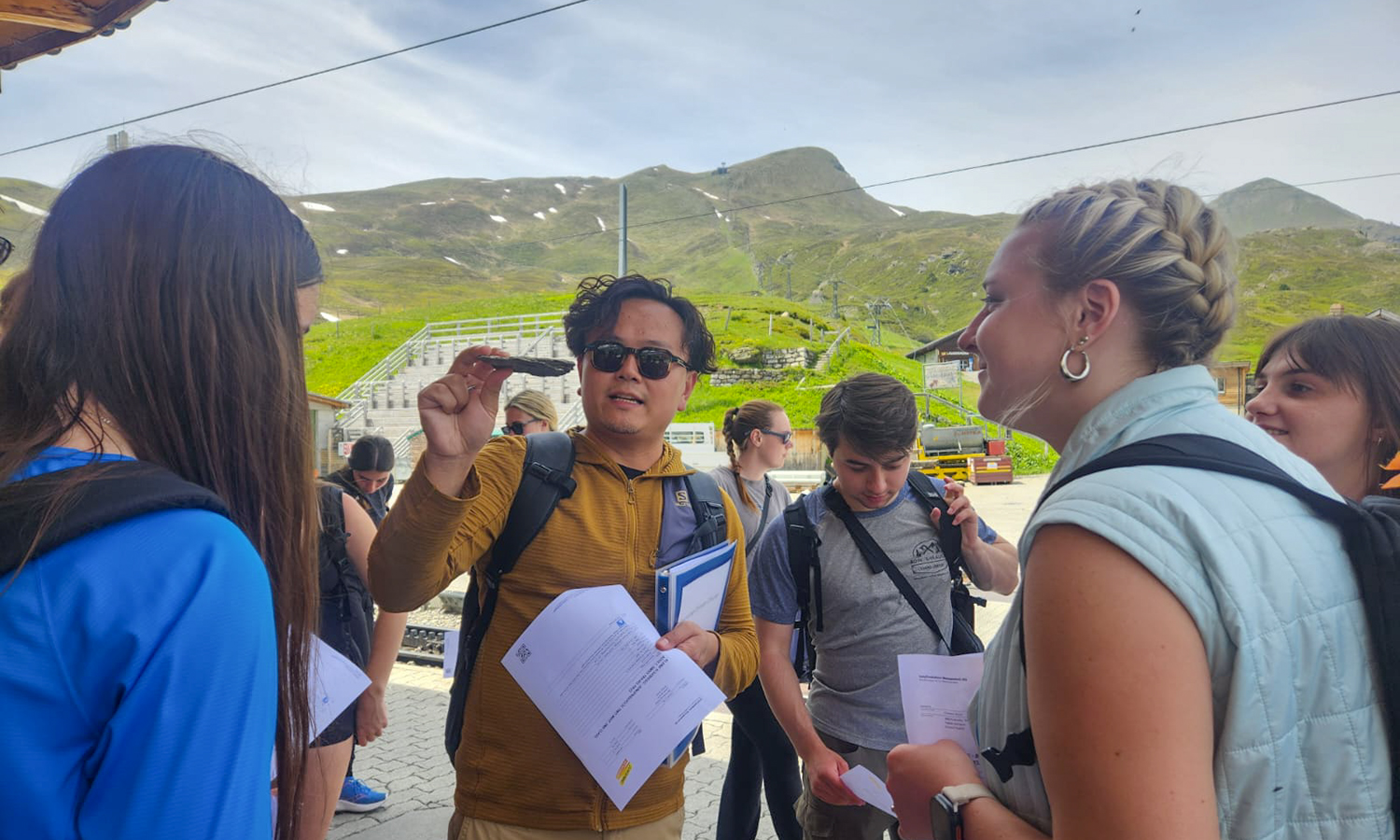 While studying abroad along the Rhine River — from the Swiss Alps to Freiburg im Breisgau, Germany — Assistant Professor of Media and Society Jiangtao Harry Gu ’13 shows students a sedimentary rock at the foot of the Jungfrau, helping to explain the region's geological history. 