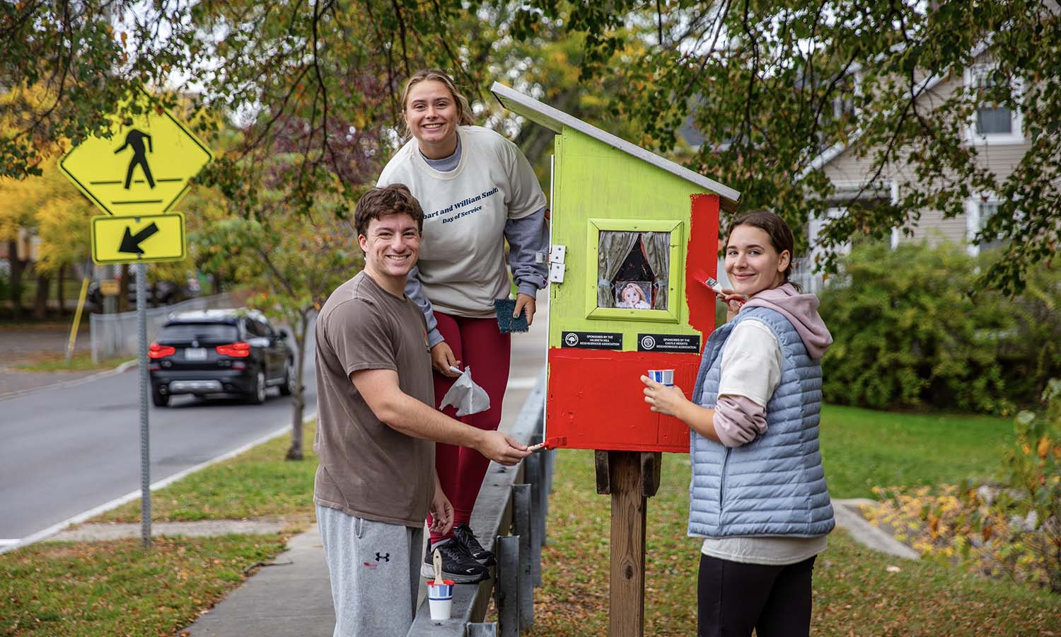 At Brook Street Park, Leyton Demeo ’27, Chloe Odell ’27 and Iona University student Jess Navarrete paint a Little Free Library during the Fall Day of Service. 