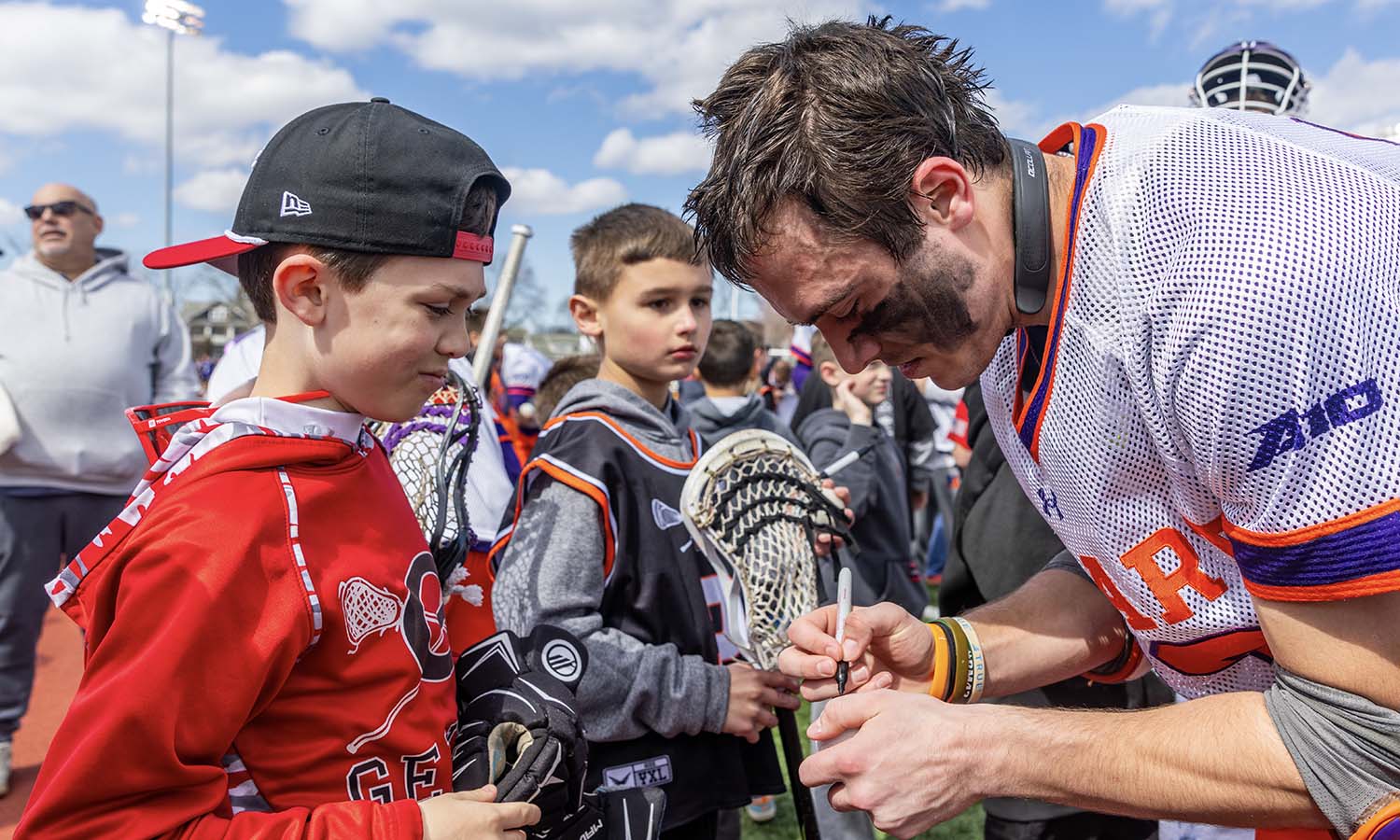 Following Hobart lacrosse’s game against High Point, Jackson Galiani ’26 signs autographs for kids from local lacrosse teams during Youth Lacrosse Day at Boswell Field. 