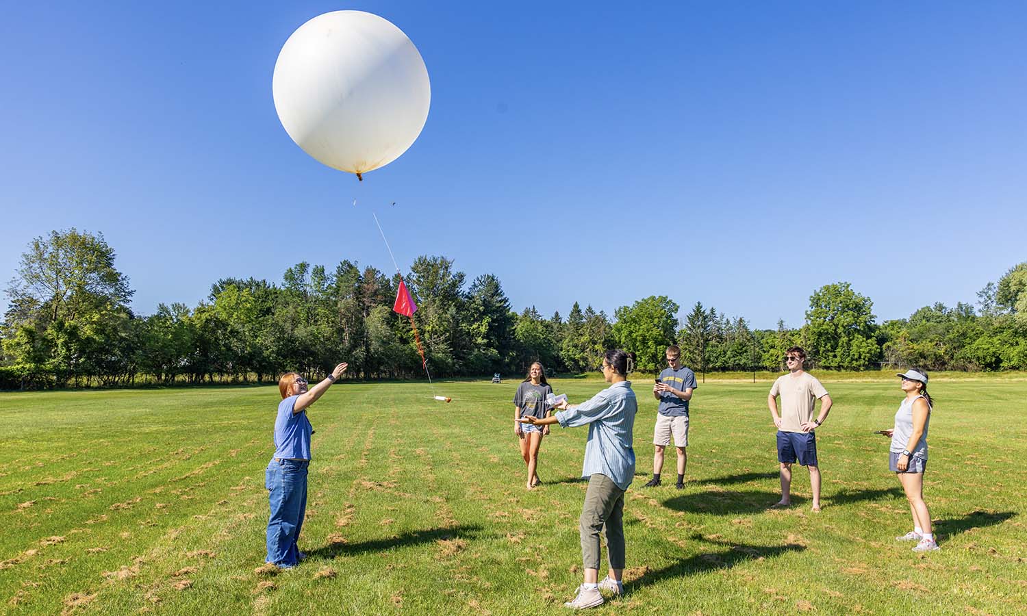 Students conducting summer research with Professor of Geoscience Neil Laird launch a weather balloon to collect data as it travels through the atmosphere.