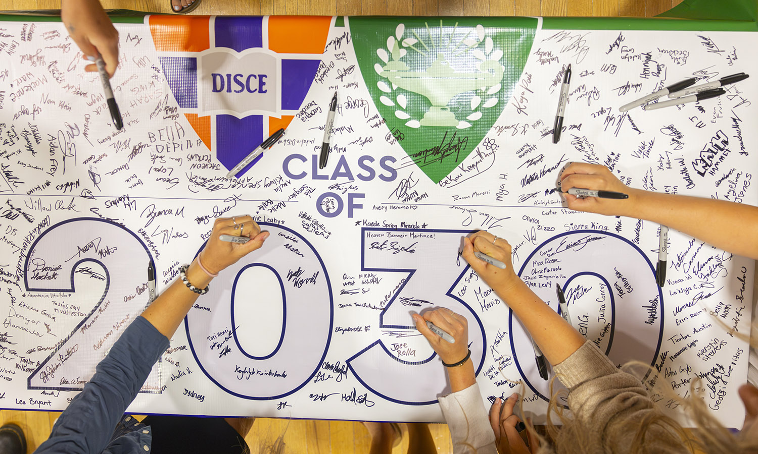 First-year students sign the Class of 2030 banner, an annual tradition.  