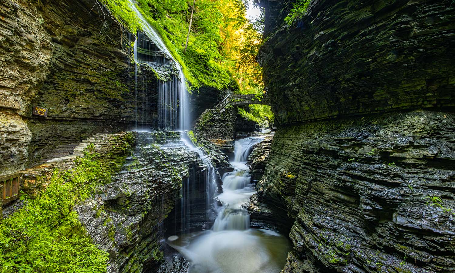 A long exposure showcases Rainbow Falls in Watkins Glen State Park on a summer morning. 