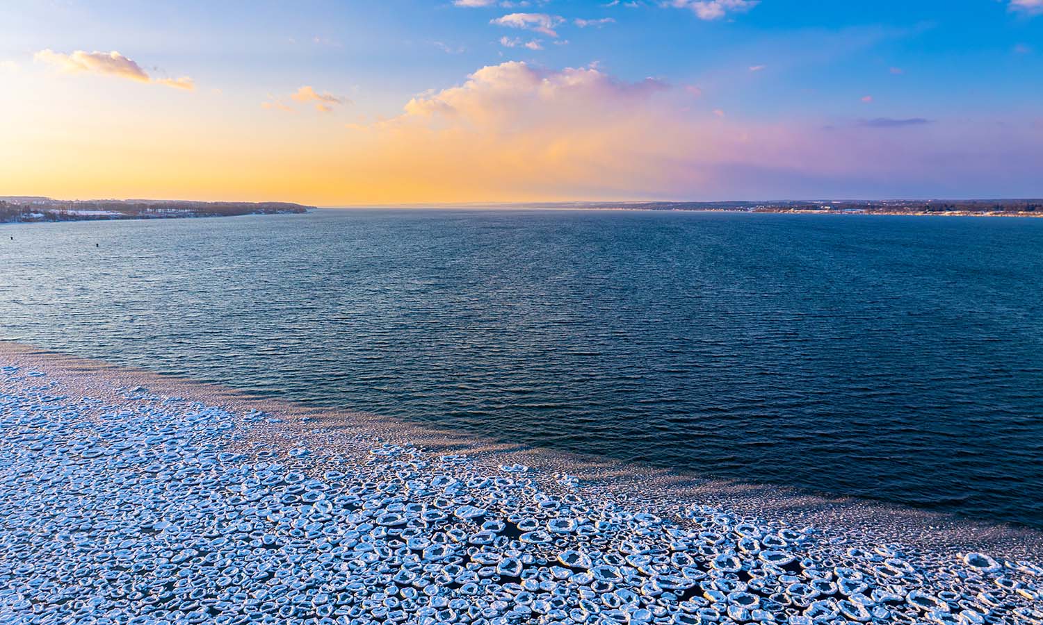 Ice forms along the northern edge of Seneca Lake at sunrise. 
