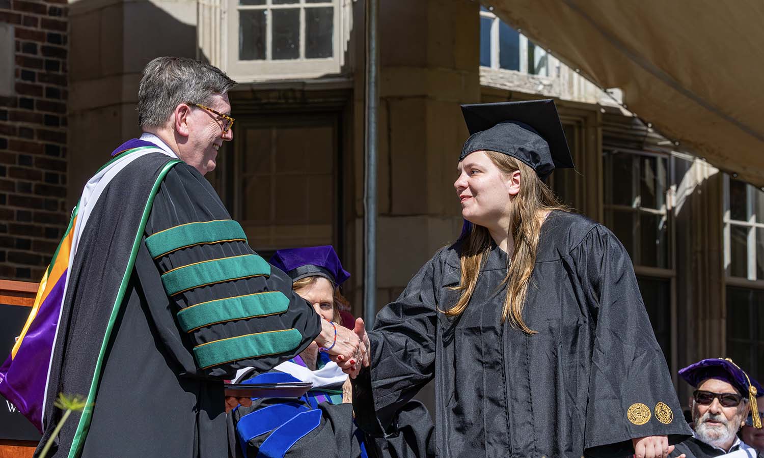 Michaela Jensen '26 receives her diploma from President Mark D. Gearan. Jensen is part of the College Experience Program, which celebrated it's 20th anniversary at HWS.  