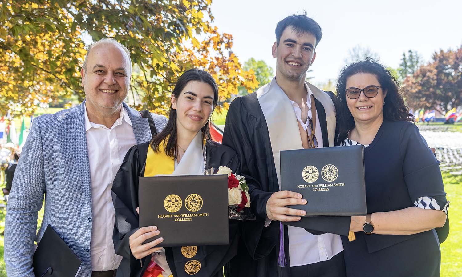Nikolina Stanich '26 and Nikola Stanich '26 pose for a photo with their parents after receiving their diplomas.  