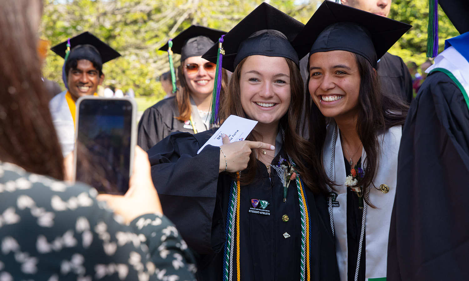 Kelly Howe '26 and Julia Texiera '26 stop for a photo during the processional.  