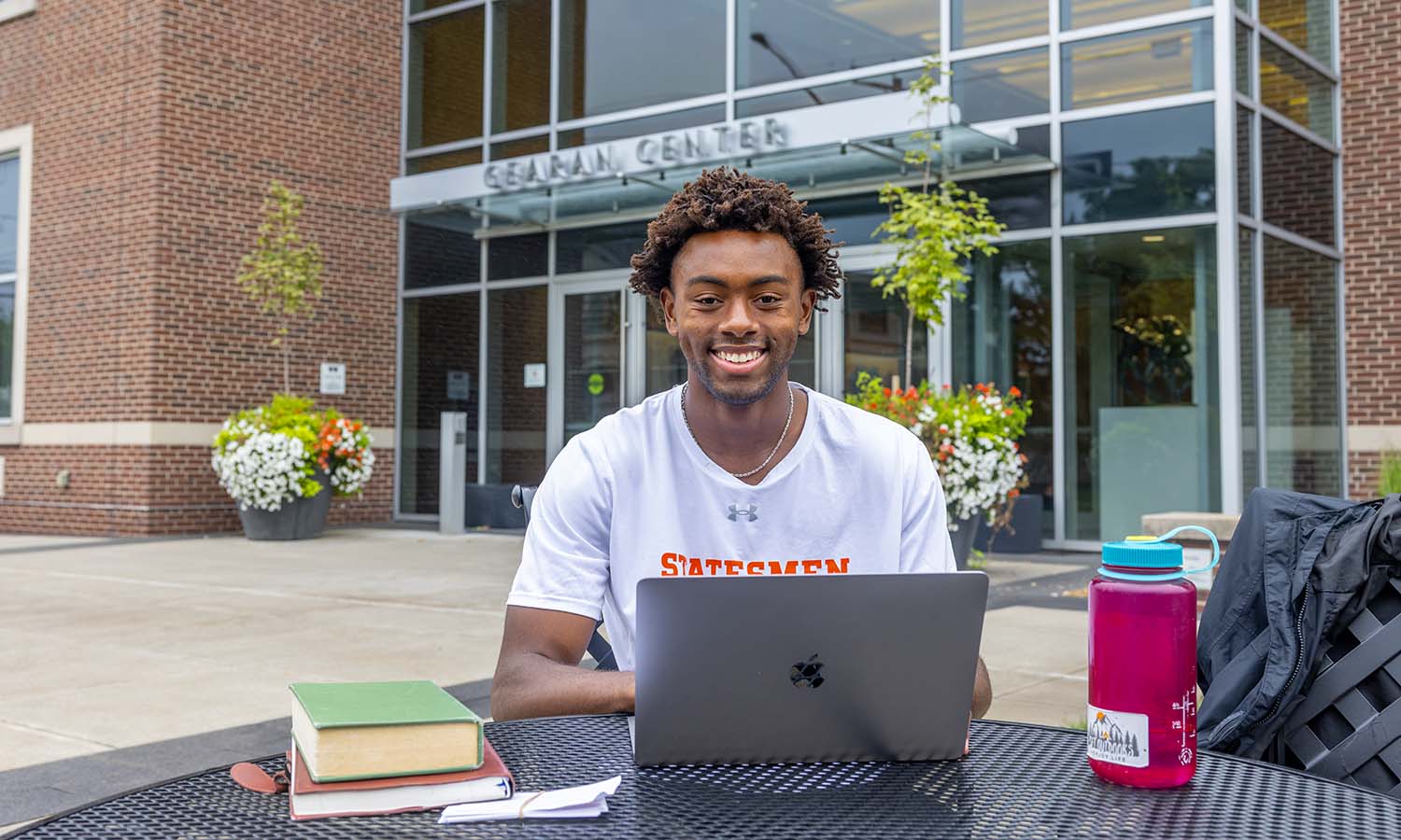 Nicholas Short ’27 sits at a picnic table in front of the Gearan Center, one of his favorite locations to study outside.&nbsp; 