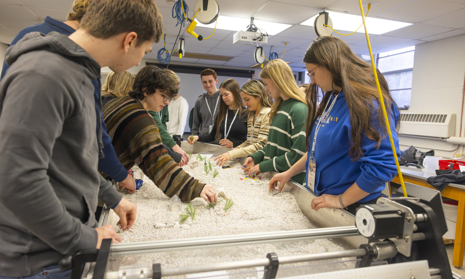 During the Admitted Student Day open house on Saturday, students and their families examine a stream table with Associate Professors of Geoscience Tara Curtin and David Finkelstein. 