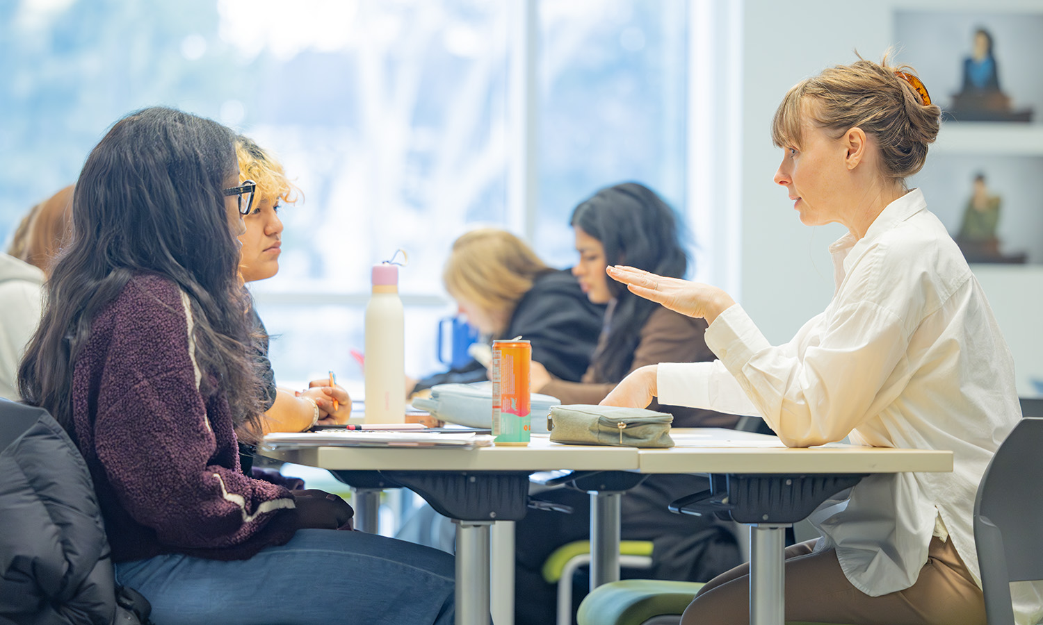 Associate Professor of Economics Christina Houseworth chats with Vanesa Castillo ‘28 and Danie DeZart ‘28 during “Micro Theory and Policy.” 