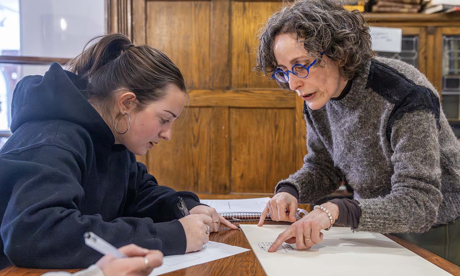 Taylor McDermott ‘28 and Associate Professor of Art and Architecture Liliana Leopardi examine a print published in Harper’s Bazaar during “Collections Management.” 