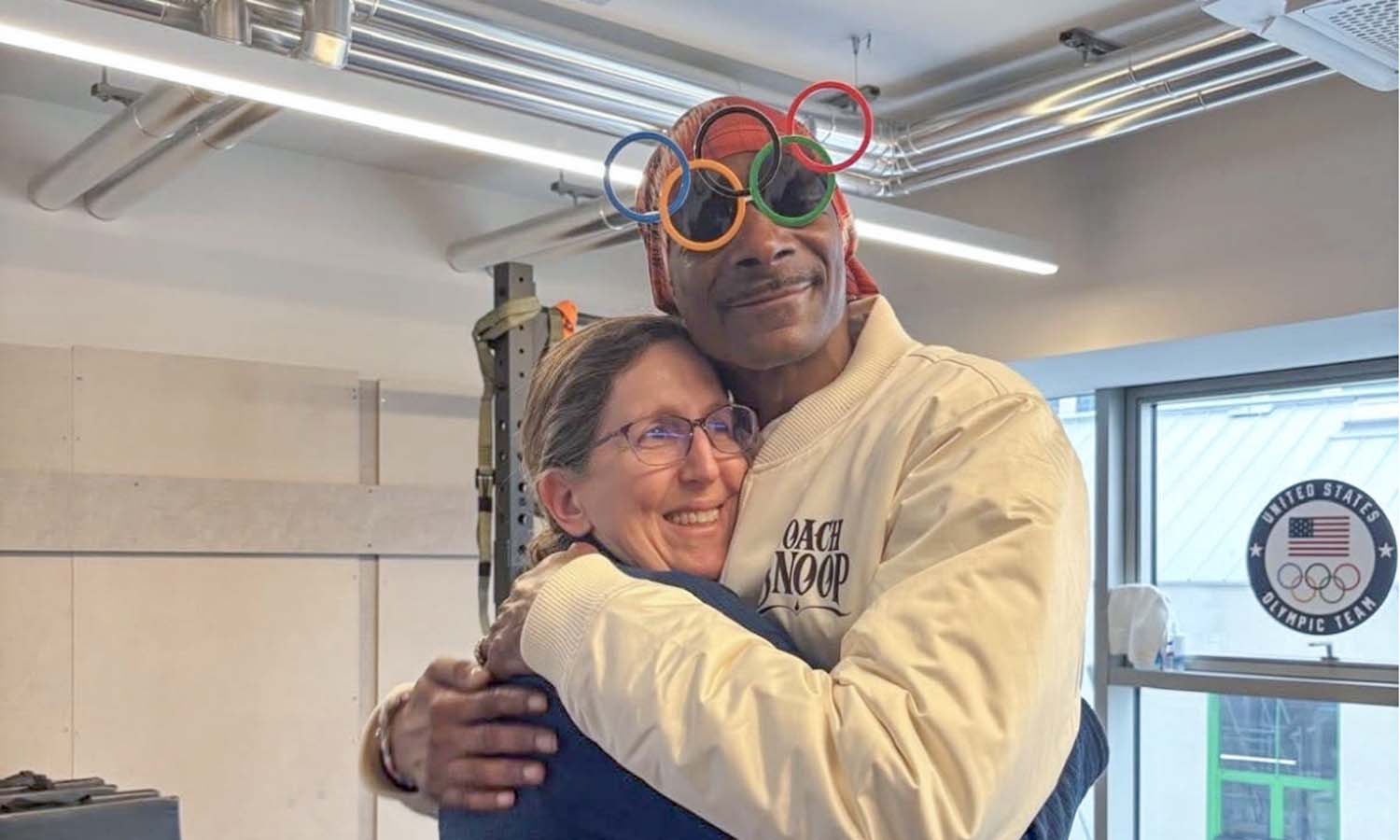 Team physician for the 2026 U.S. Olympic Women’s Hockey team Dr. Allyson Shirtz Howe ’94, P’25 receives a hug from Snoop Dogg while at the Milan Cortina games. 
