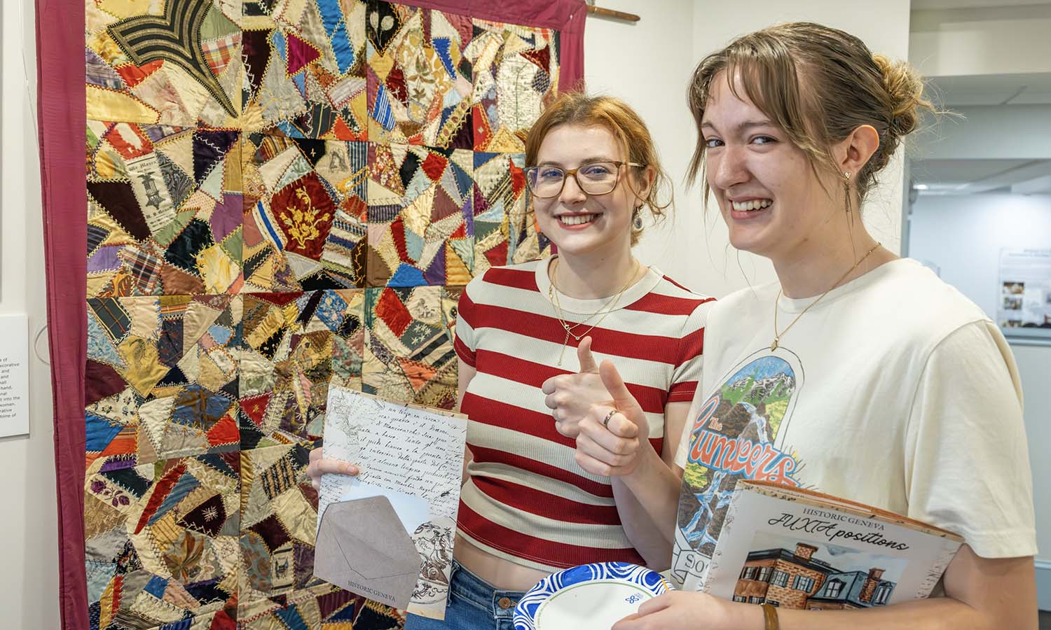 At the Geneva History Museum, Lucy Ruff ‘29 and Amelia Roberts ‘29 pose for a photo while showcasing their work from “Introduction to Critical Museum Studies” with Professor of American Studies Elizabeth Belanger. 