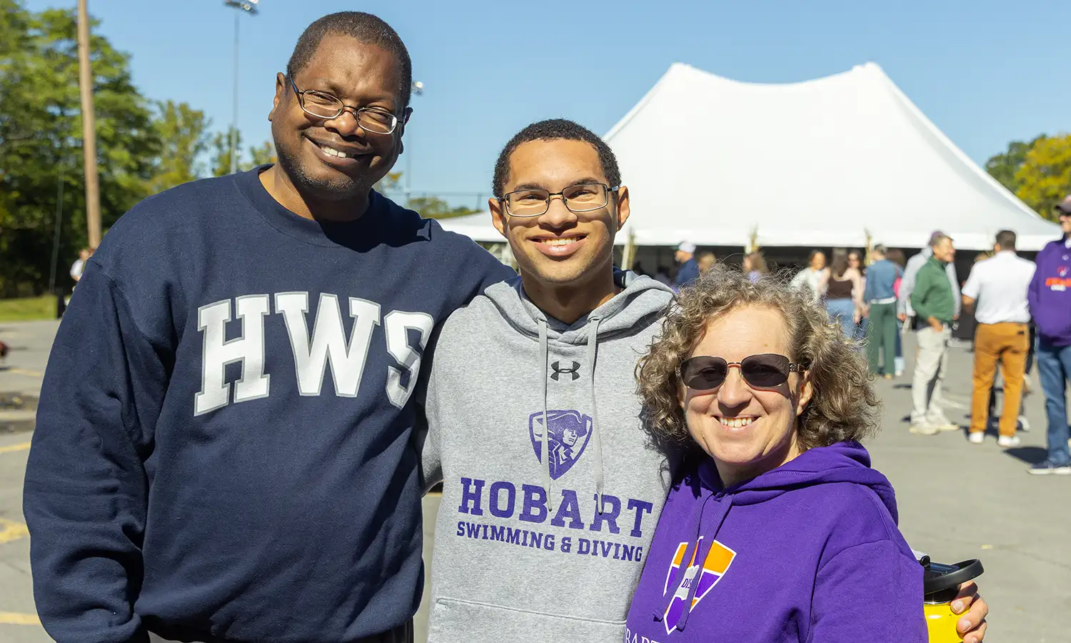 Christopher Woody '27 (center) and his parents pose for a photo while attending Homecoming and Family Weekend. 