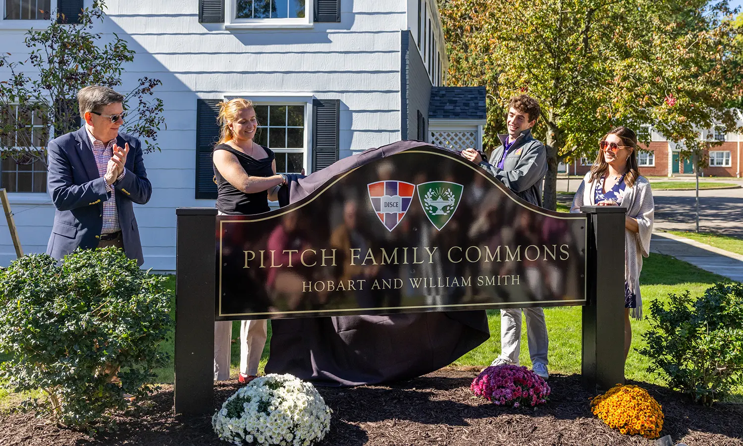 President Mark D. Gearan, Student Trustees Cori Bohan ‘27 and Rupert Ramsay ‘27 and Vice President for Campus Life and Dean of Students Becca Morris unveil the sign at the Piltch Family Commons, a new townhouse-style residential student housing community on Pulteney Street. 