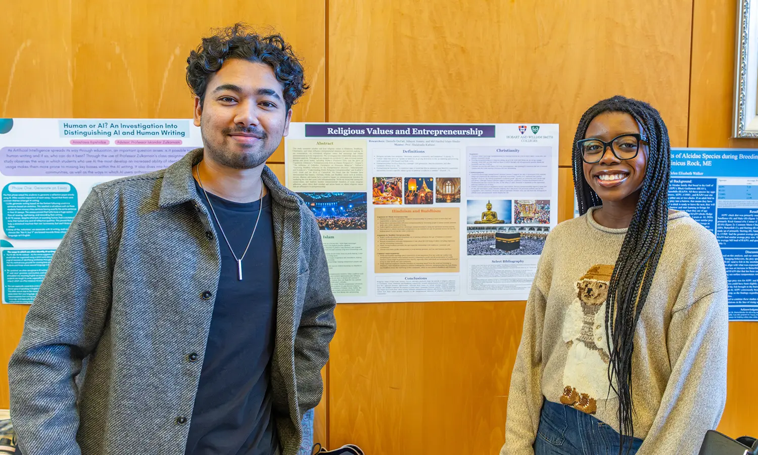 Jubayer Ansary '29 and Danielle Dezart '28 pose in front of their summer research project conducted alongside Associate Professor of Religious Studies Shalahudin Kafrawi. 
