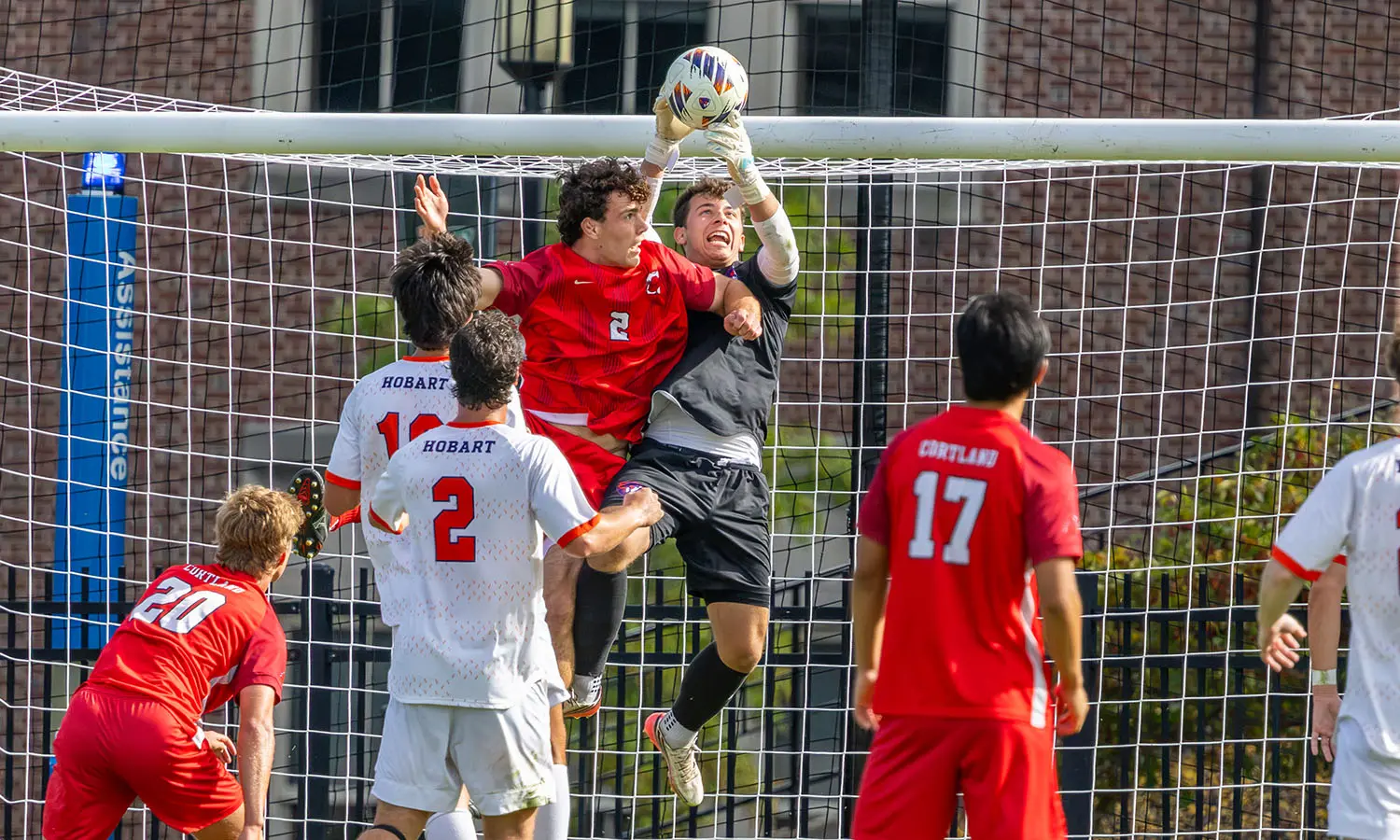 Hobart Soccer goalkeeper Jake Hans '28 goes up for a ball on a free kick versus Cortland. 