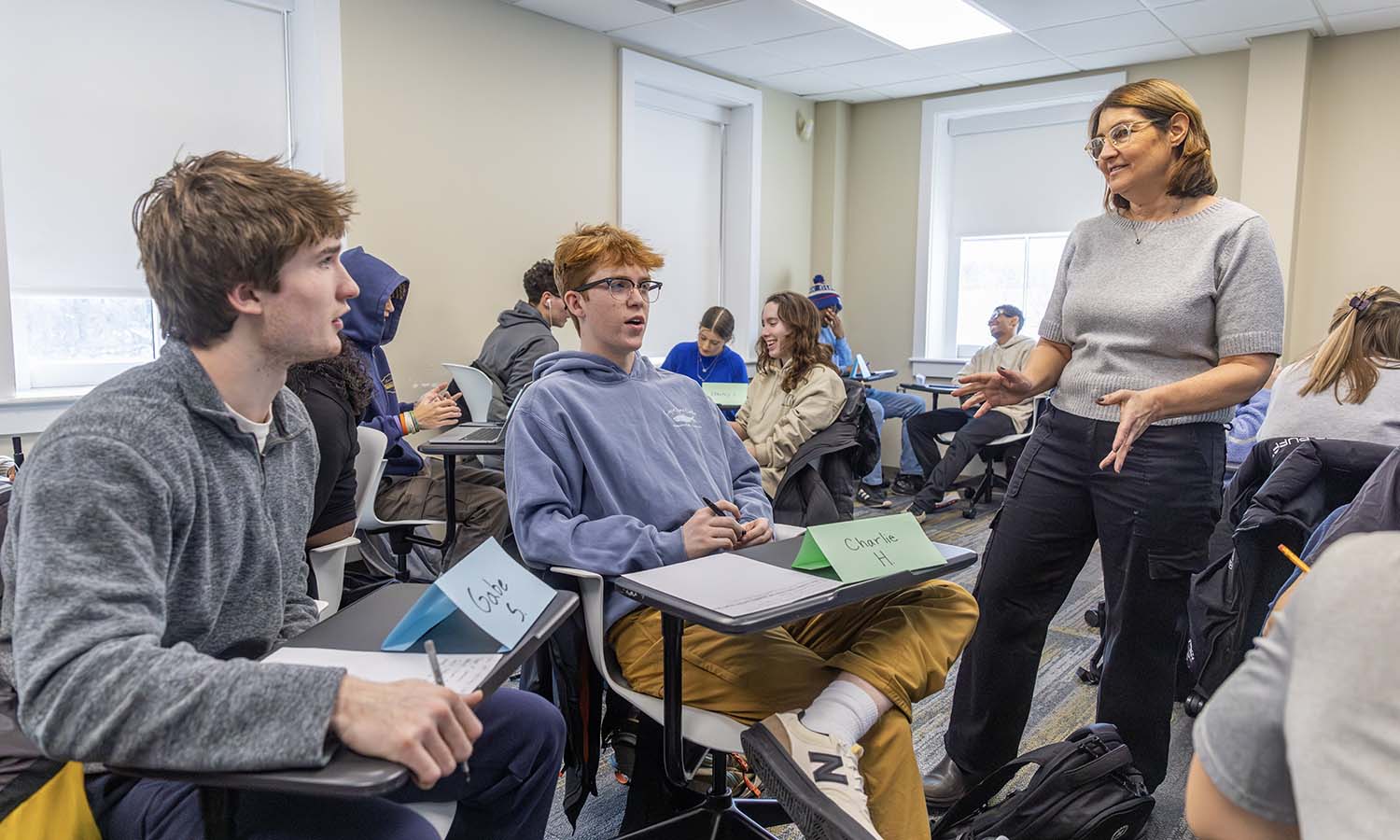 While working on an interview exercise, Gabe Smith ’29 and Charlie Hamilton ’29 speak with Visiting Assistant Professor of Management and Entrepreneurship Erinn Ryen during “Entrepreneurial Leadership.” 
