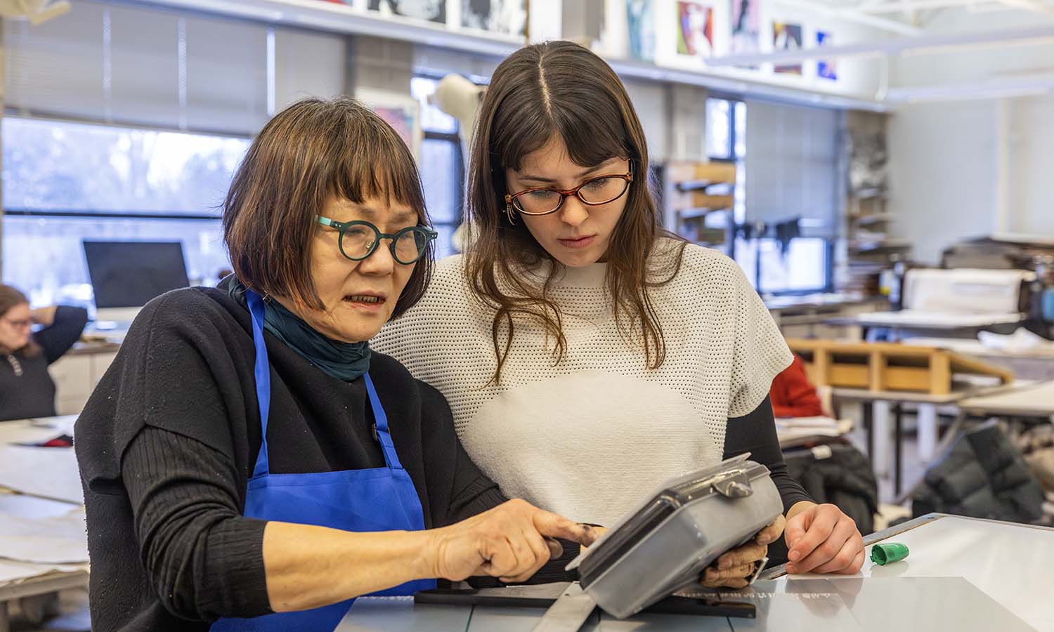 Manuela Taff-Freire ’27 receives feedback on her artwork from Professor of Art and Architecture Phillia Yi during “Intaglio Printing.” 