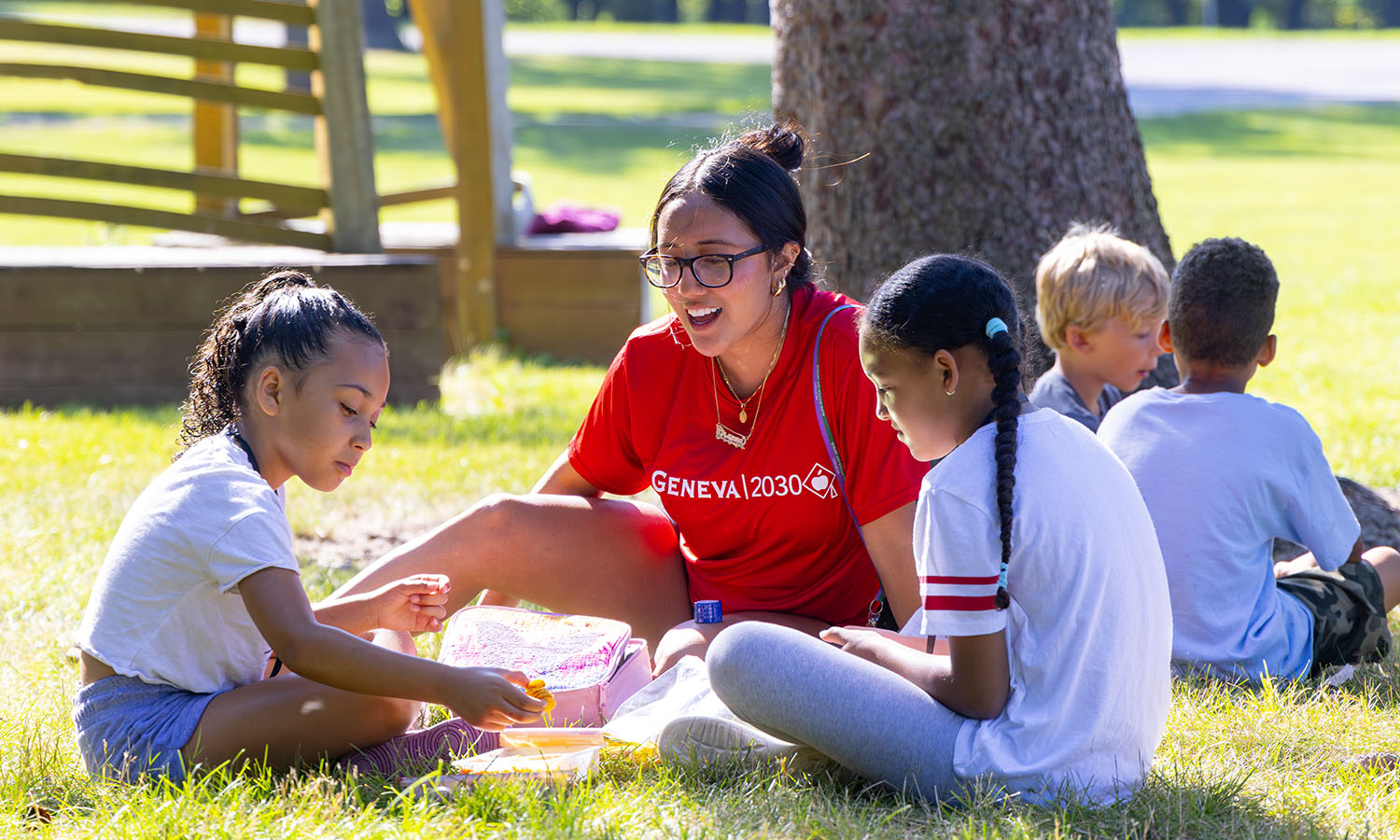 Brianna Lucero '27 visits with children during snack time in Geneva 2030's Students Outside All Summer (SOS) program, which combines outdoor exploration, literacy, STEAM and tutoring for children in grades 1-5 and is hosted at HWS. 