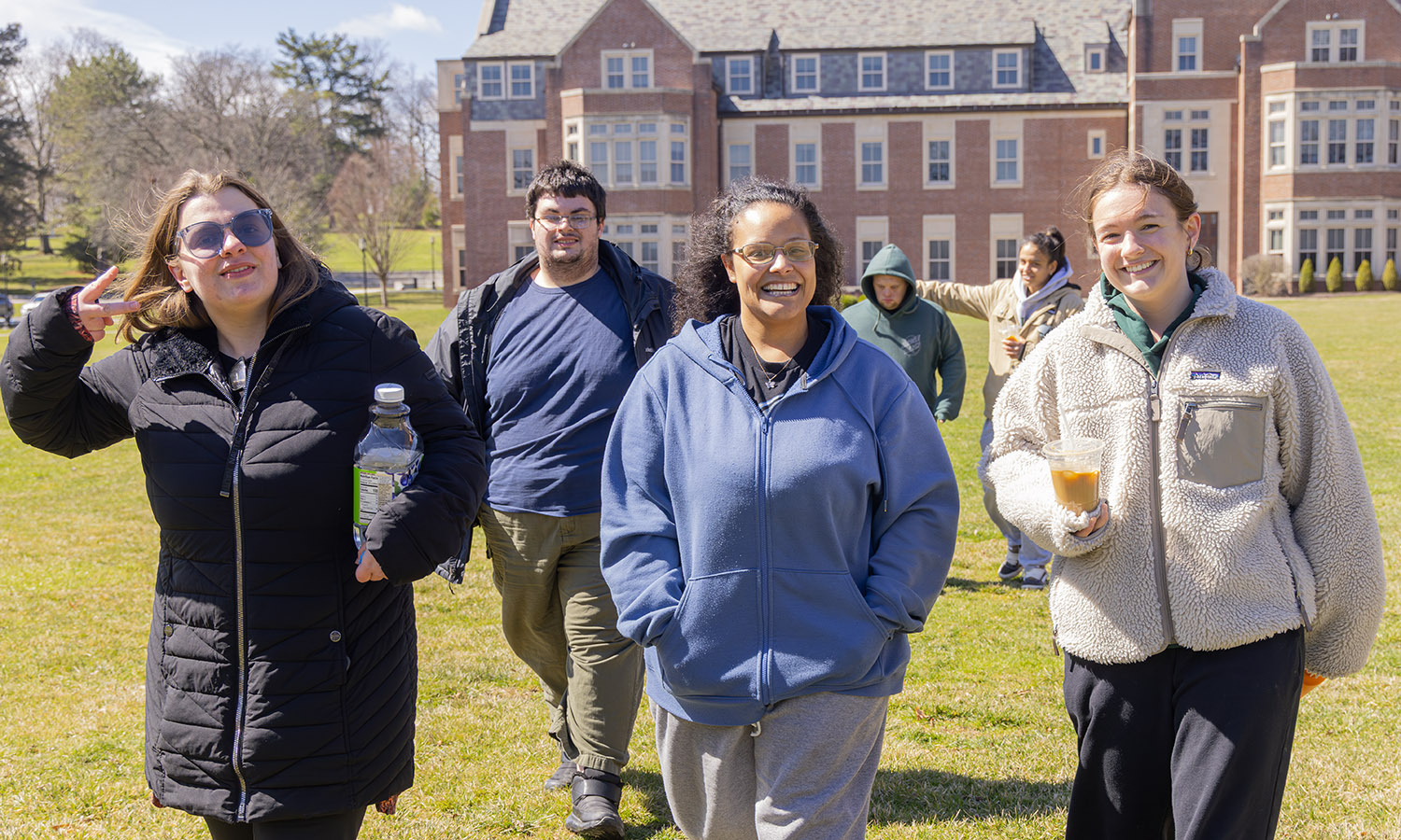 Kelly Howe '26 (right) and Julia Texiera '26 (back right) and students from the College Experience program walk across Stern Lawn after observing an experiment with Assistant Professor of Chemistry Matthew Church. 