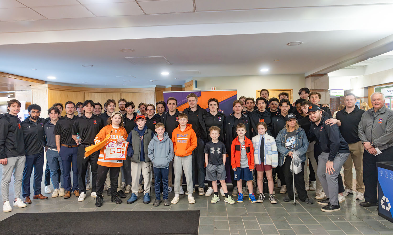 Hobart hockey players pose with youth athletes in the Scandling Student Center during a celebration of the team’s national runner-up finish. 