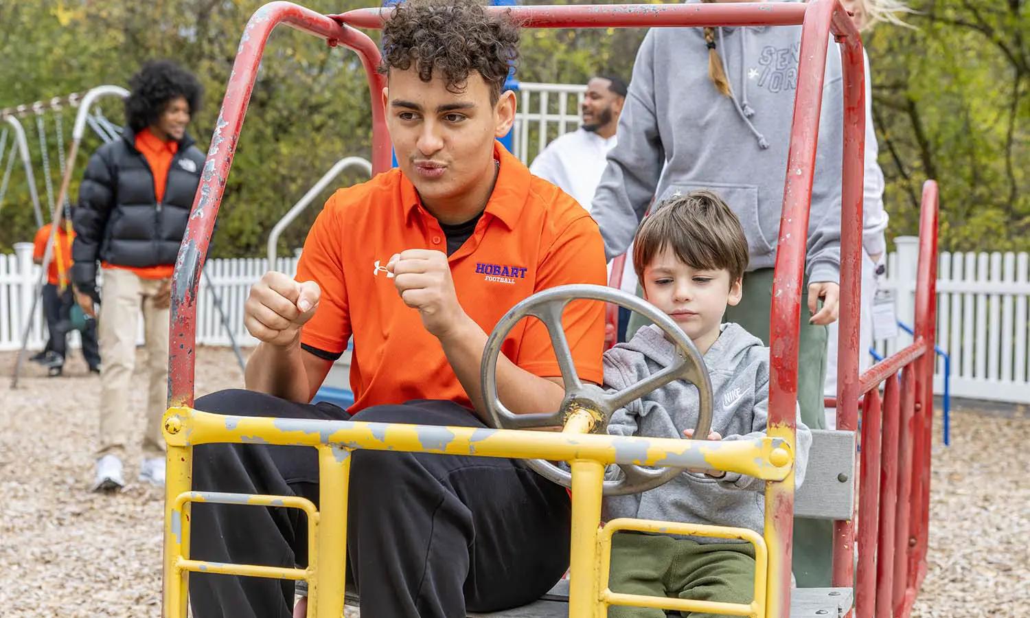Members of the Hobart football team visit Happiness House in Geneva. Here, Braedon Serna ’28 is on the playground with students. 