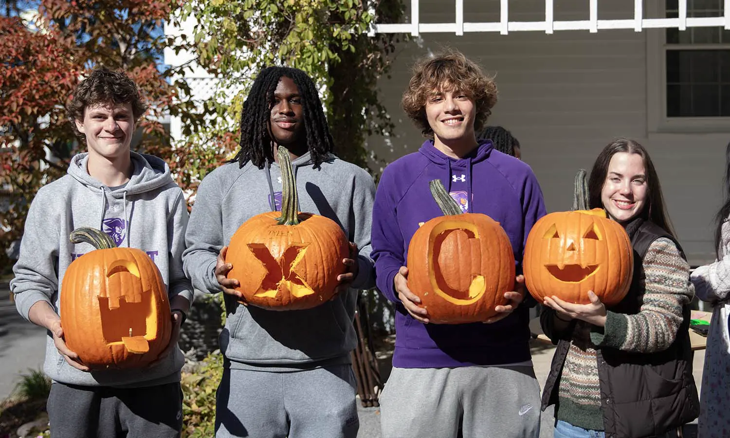 Kai Wilson '30, Chris Charles '29, Nathan Bickett '29 and Reese Wishard '29 show off their Cross Country themed pumpkins carved at the President’s home. 