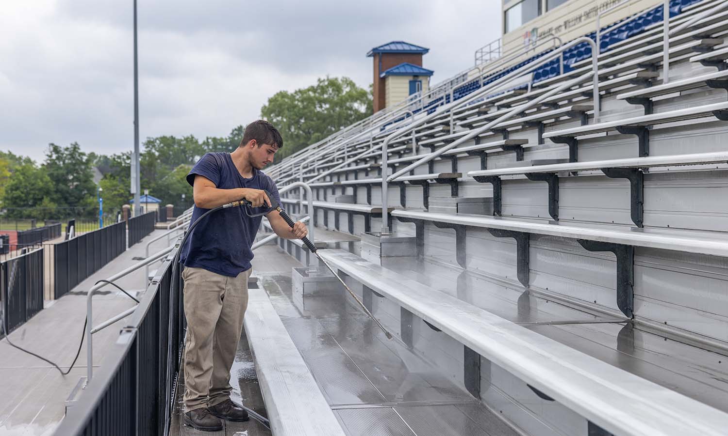 Groundskeeper Joe McCann power washes the bleachers of the David J Urick Stadium at Boswell Field. 