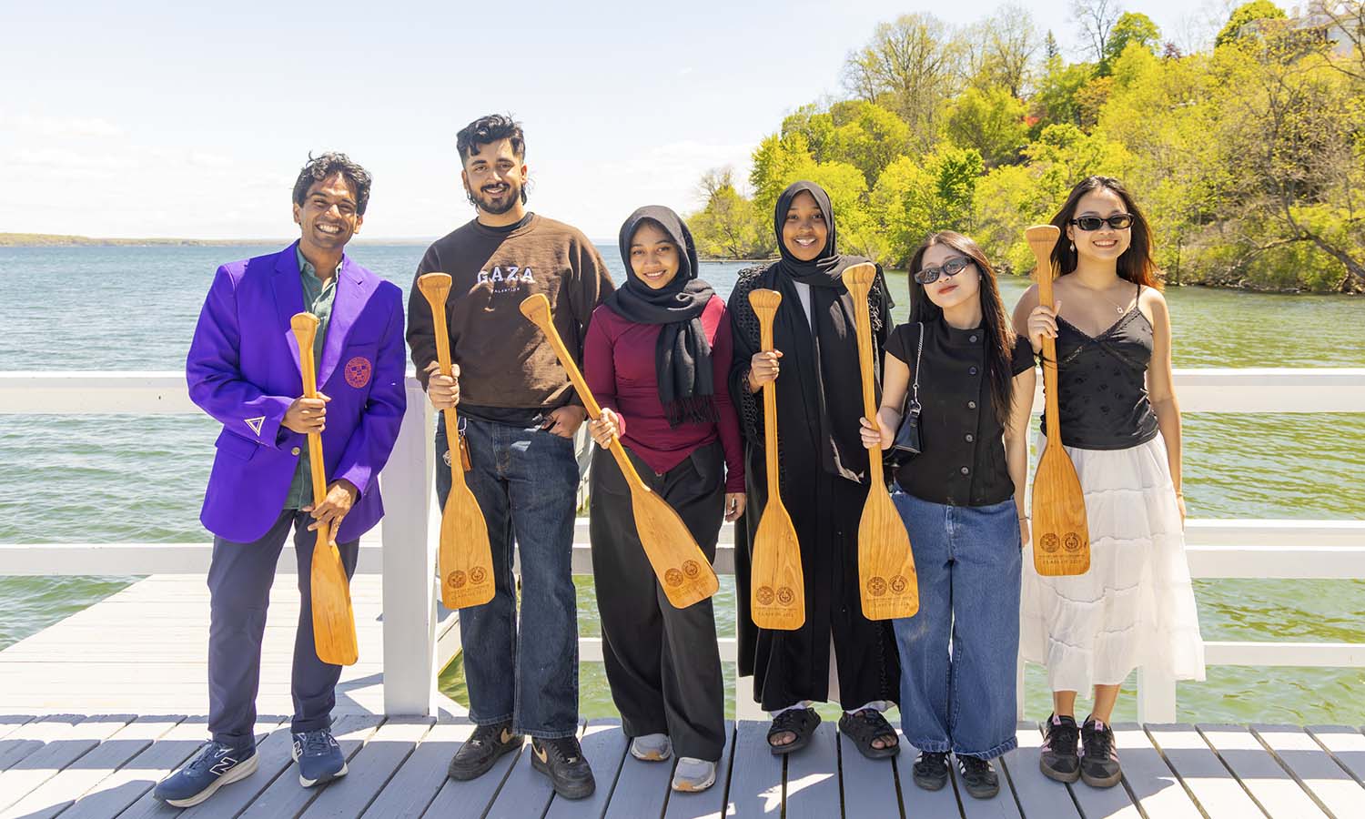 Seniors pose for a photo with their paddles. 