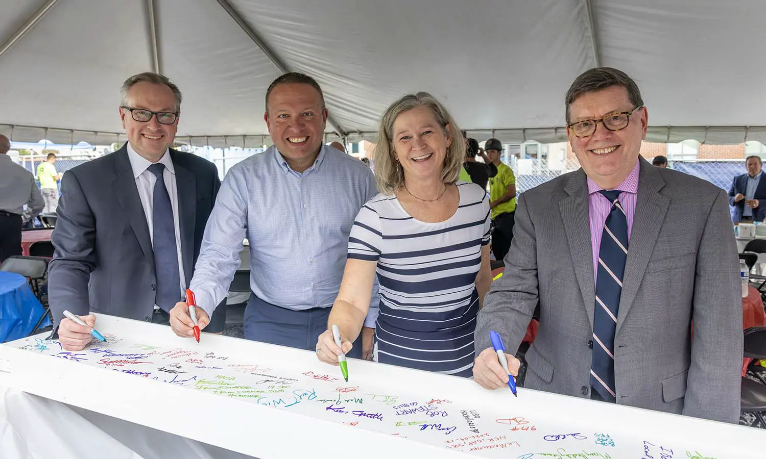 President of Suffolk Design Chris Lanzisera, Professor of Geoscience Nick Metz, Provost and Dean of Faculty Sarah Kirk and President Mark D. Gearan sign the final beam to be placed in the Fish Center for the Sciences during the “Topping Off” ceremony. 