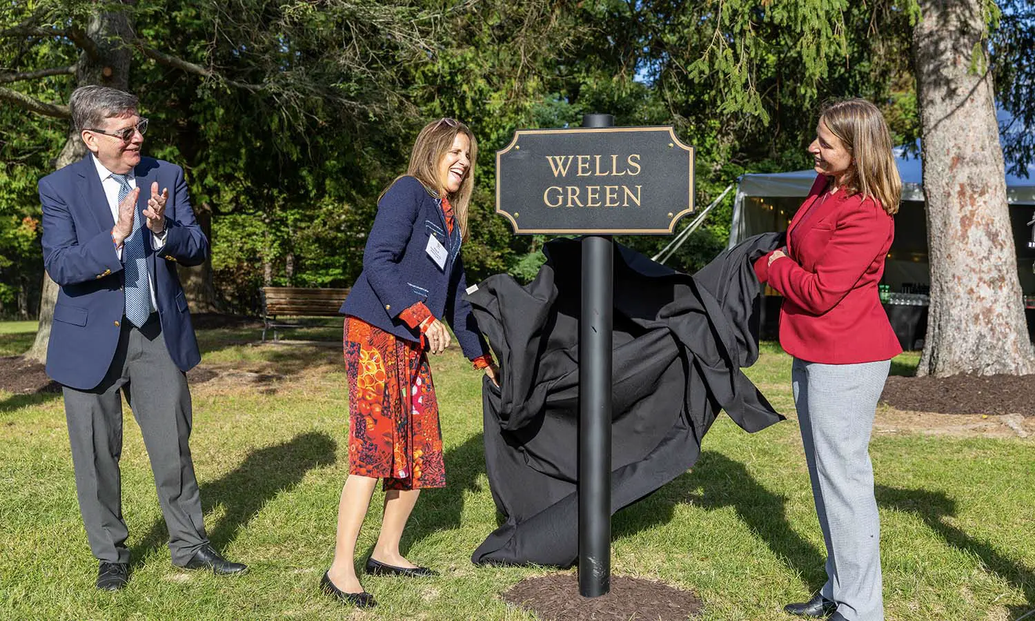 President Mark D. Gearan, Trustee Mary K. Pastore Cryan, Wells College ’84, P’15, P’16 and Associate Vice President and Director of International Enrollment and Success Marylyn Uhnak, Wells College ‘01 unveil the signage for the newly dedicated Wells Green outside of Houghton House during the Wells Welcome Weekend.  