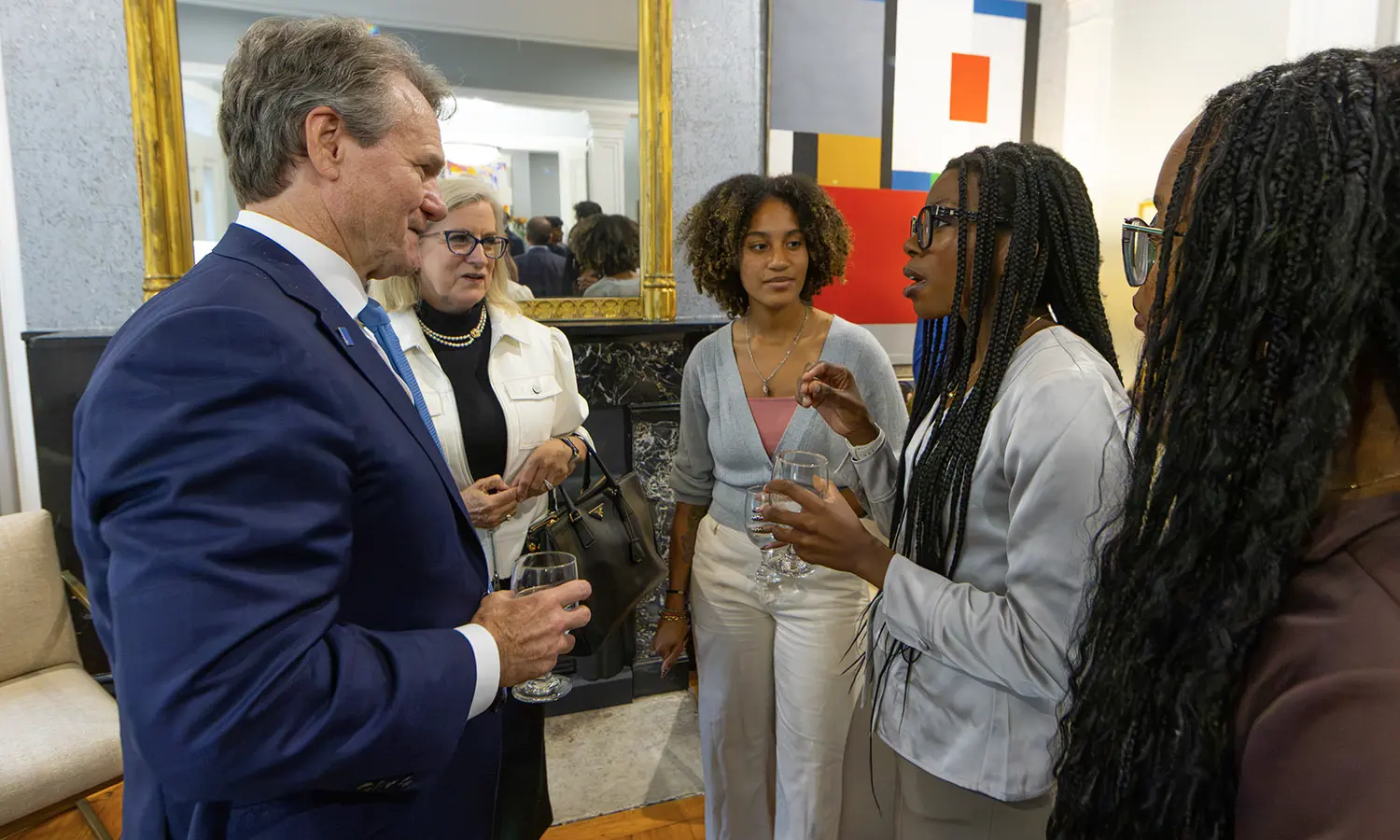 Danielle Dezart '28 speaks with Bank of America Chair of the Board and Chief Executive Officer Brian Moynihan and HWS Trustee Aileen D. Gleason ’85 at the President's residence. 